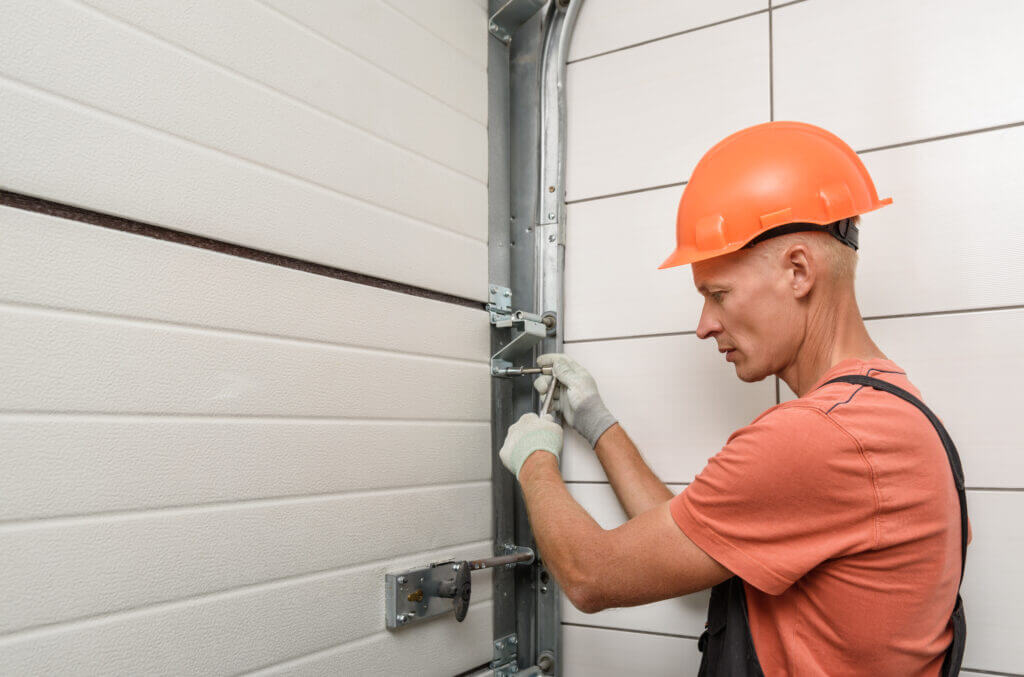 Worker is installing lift gates in the garage door springs replacement.